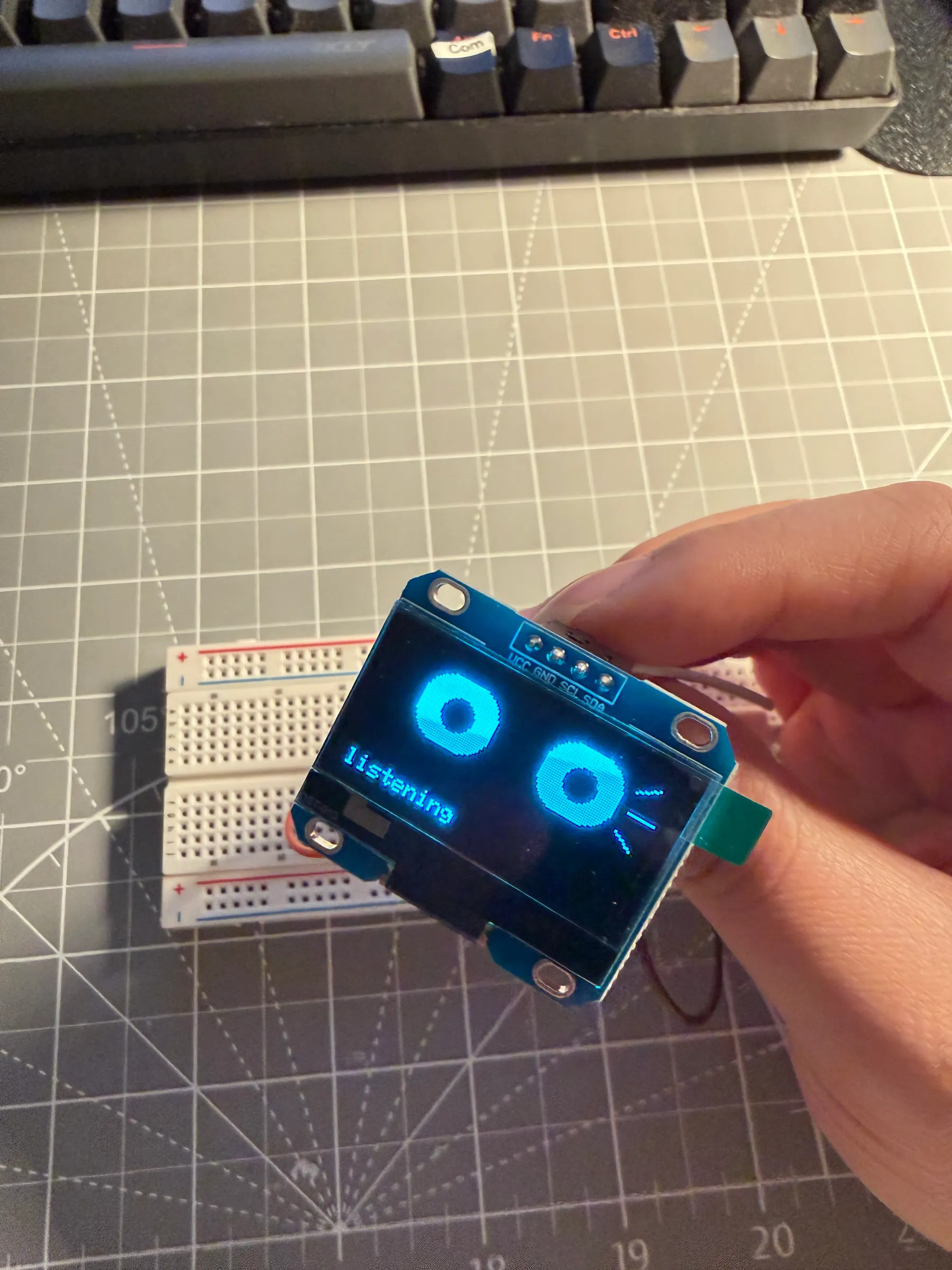 小型 OLED 屏幕上显示蓝色机器人双眼