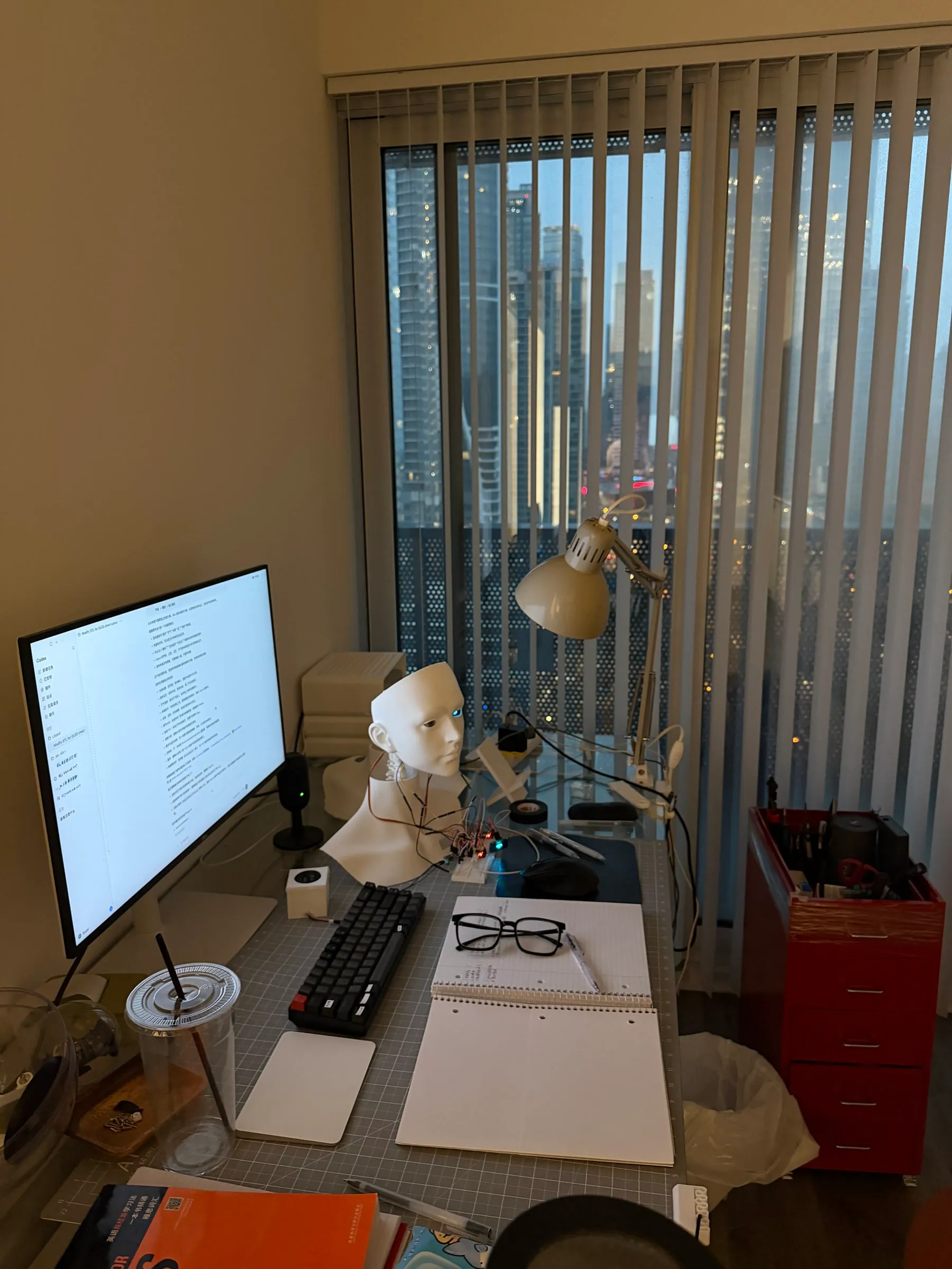 靠窗工作台上的电脑、机器人和工具